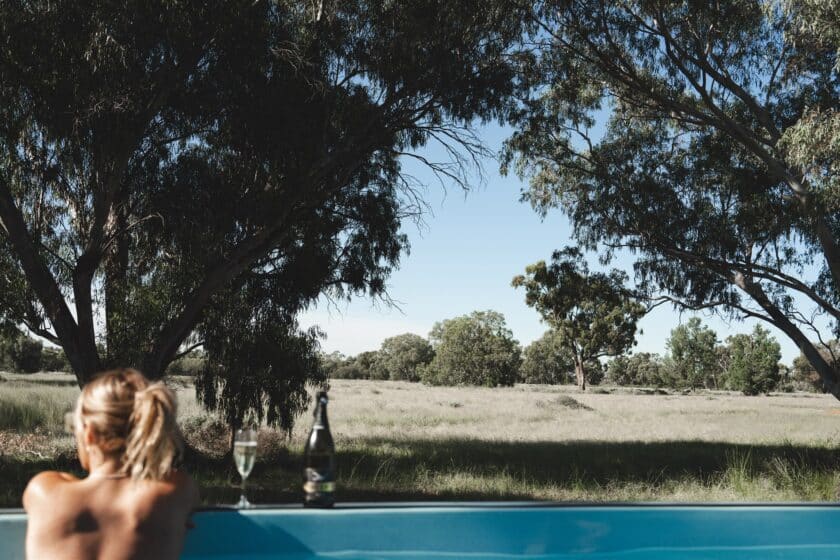 Women enjoying a glass of wine in a mineral shipping container pool in the outback