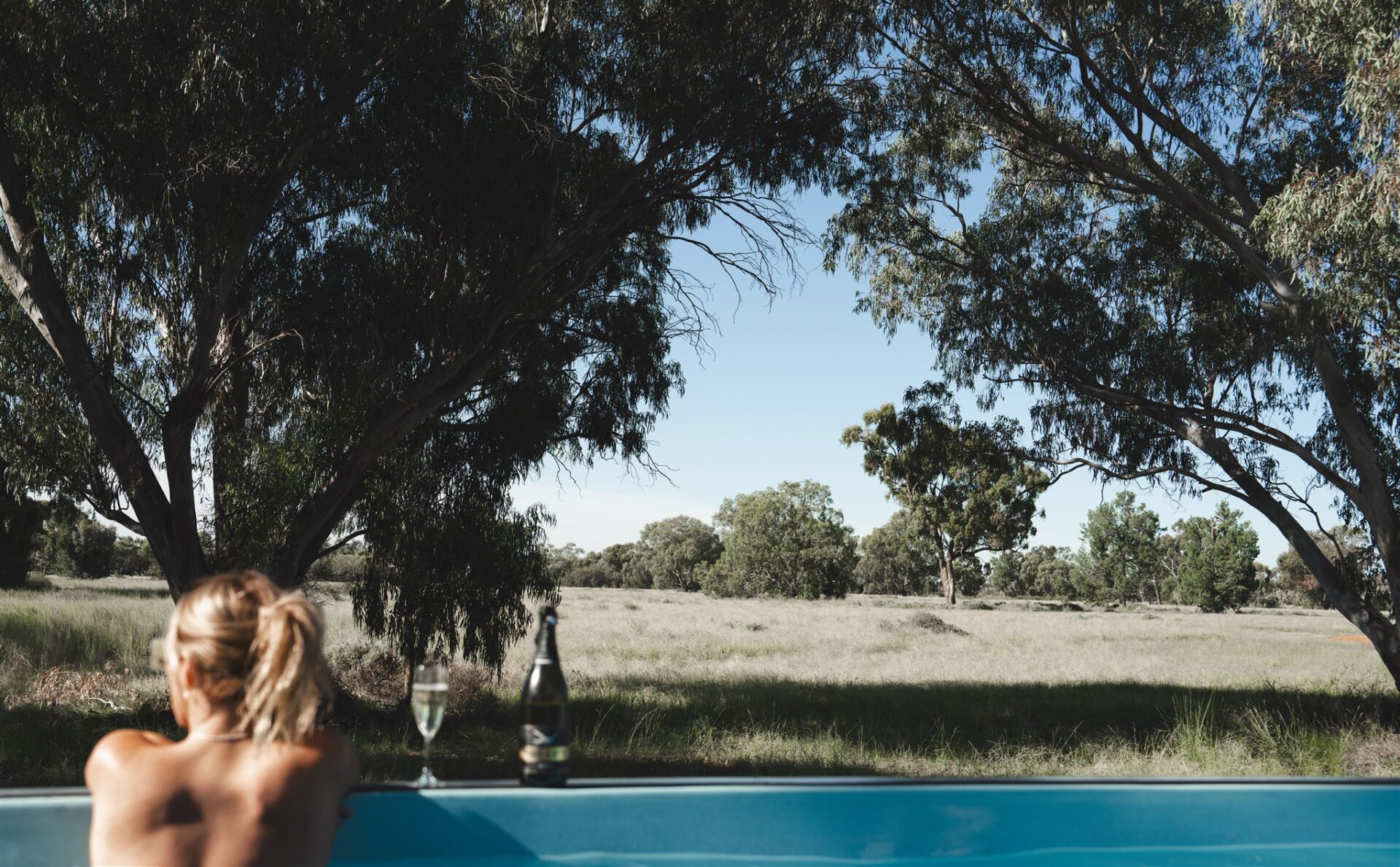 Women enjoying a glass of wine in a mineral shipping container pool in the outback