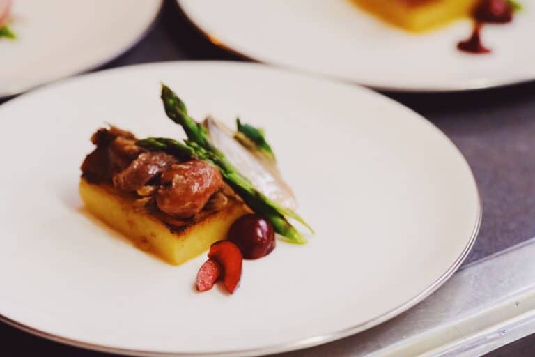 Fine dining plate featuring braised meat, asparagus, and polenta at Callubri Station.