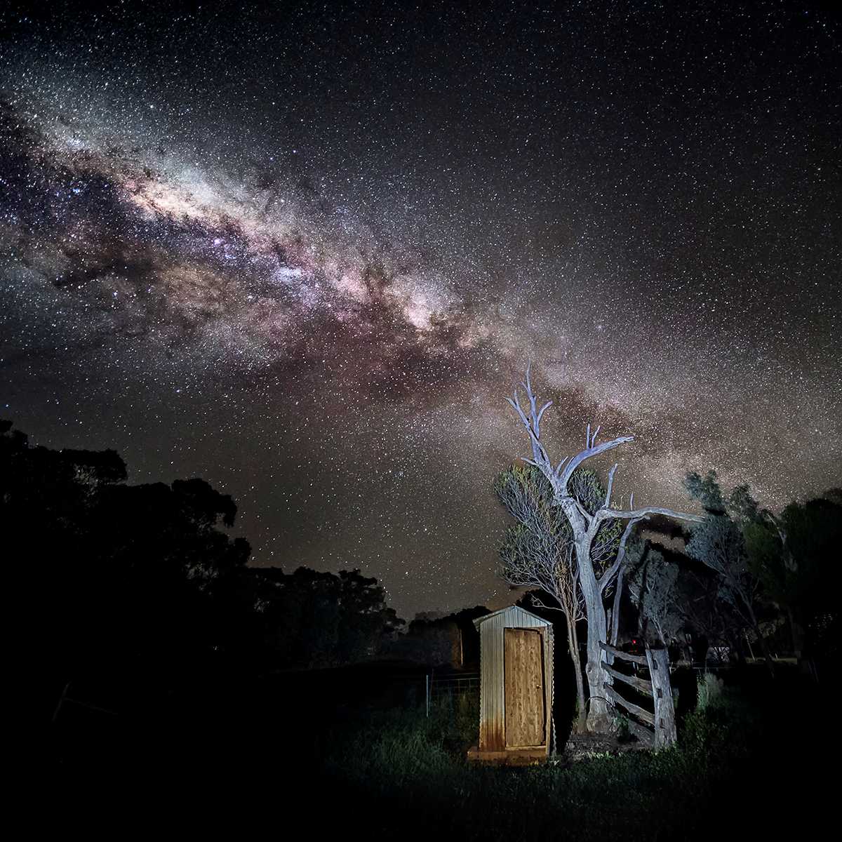 Milky Way above rustic outdoor toilet